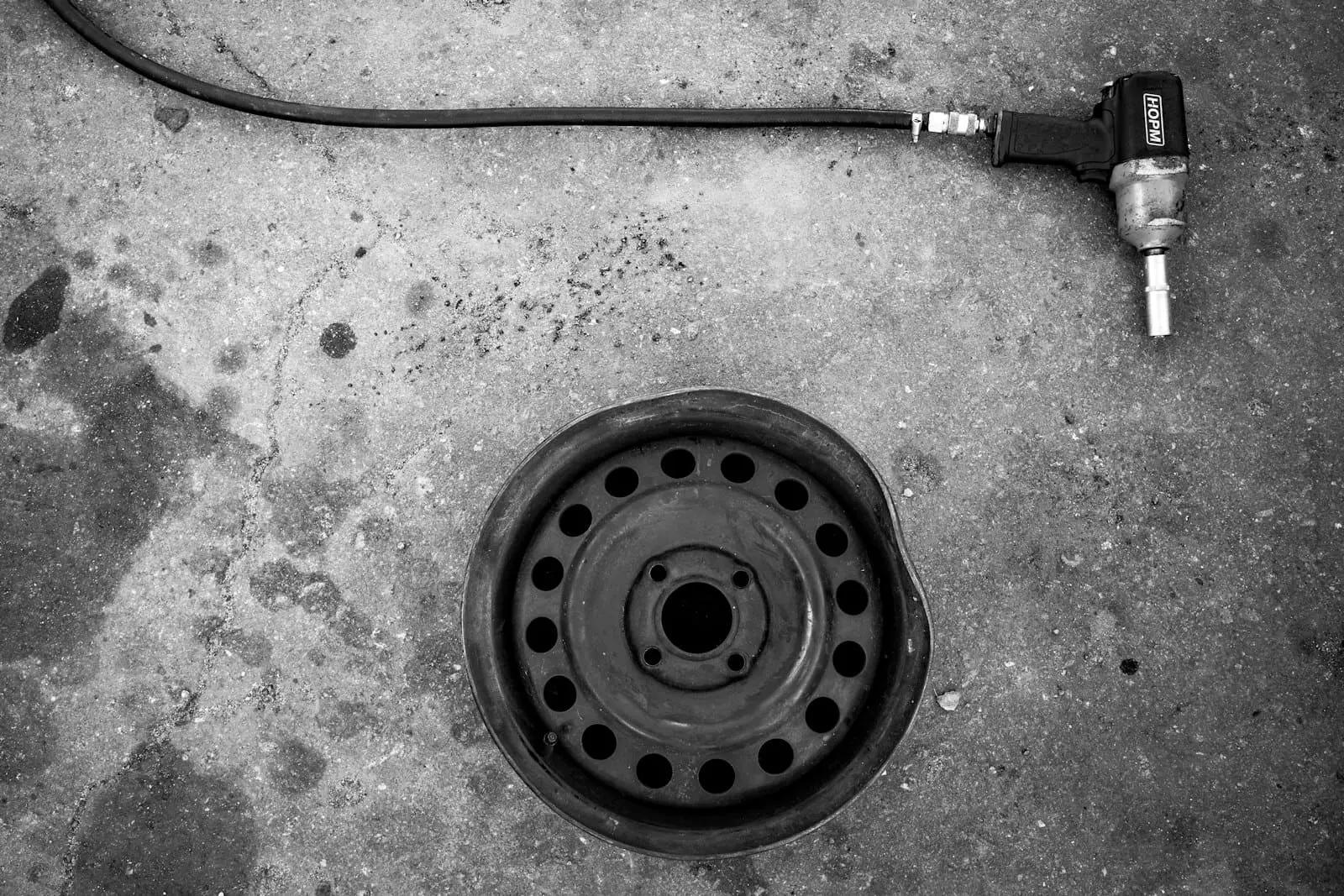 A car wheel and an impact wrench on a concrete floor