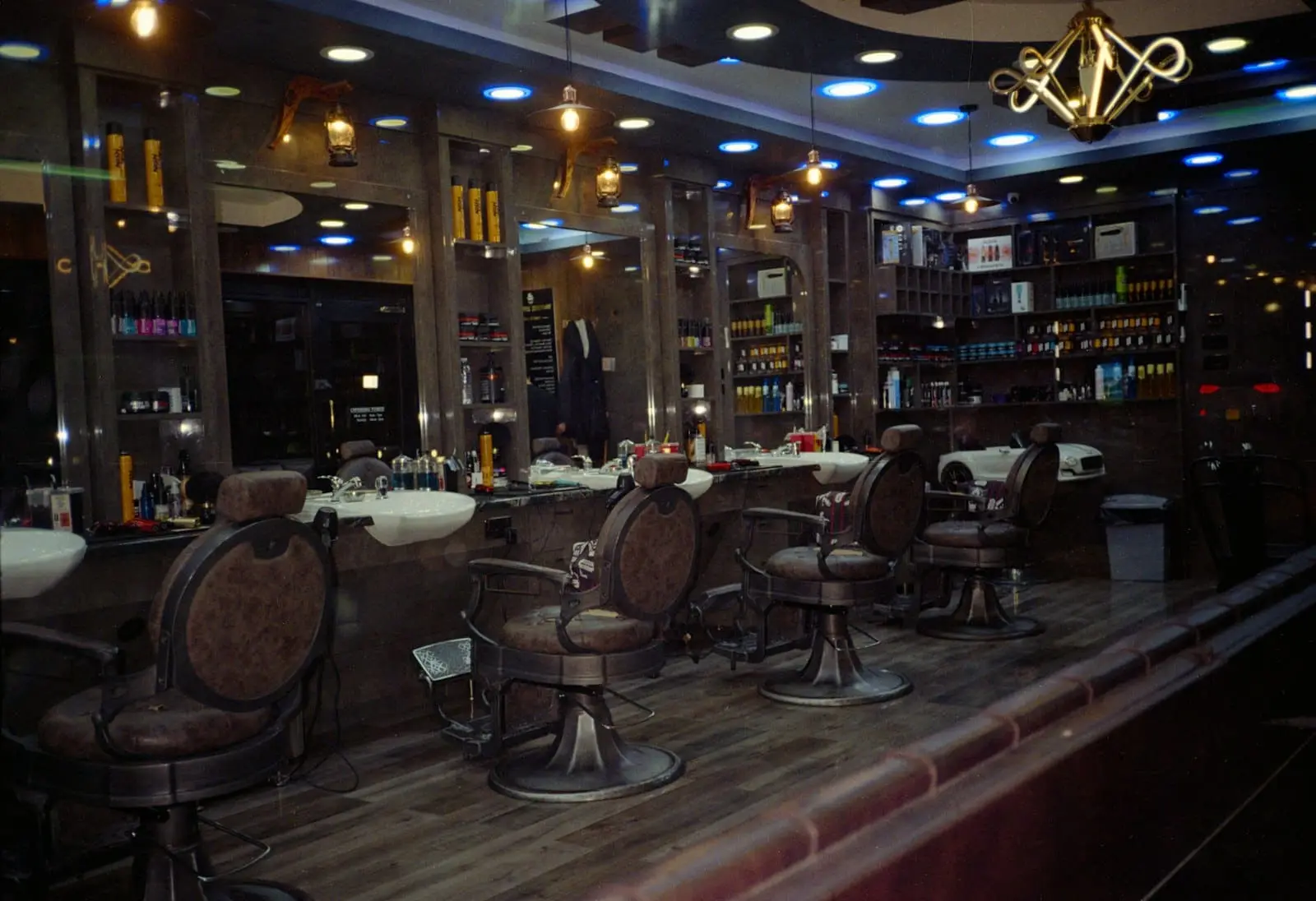 A barbershop interior with leather barber chairs and mirrors