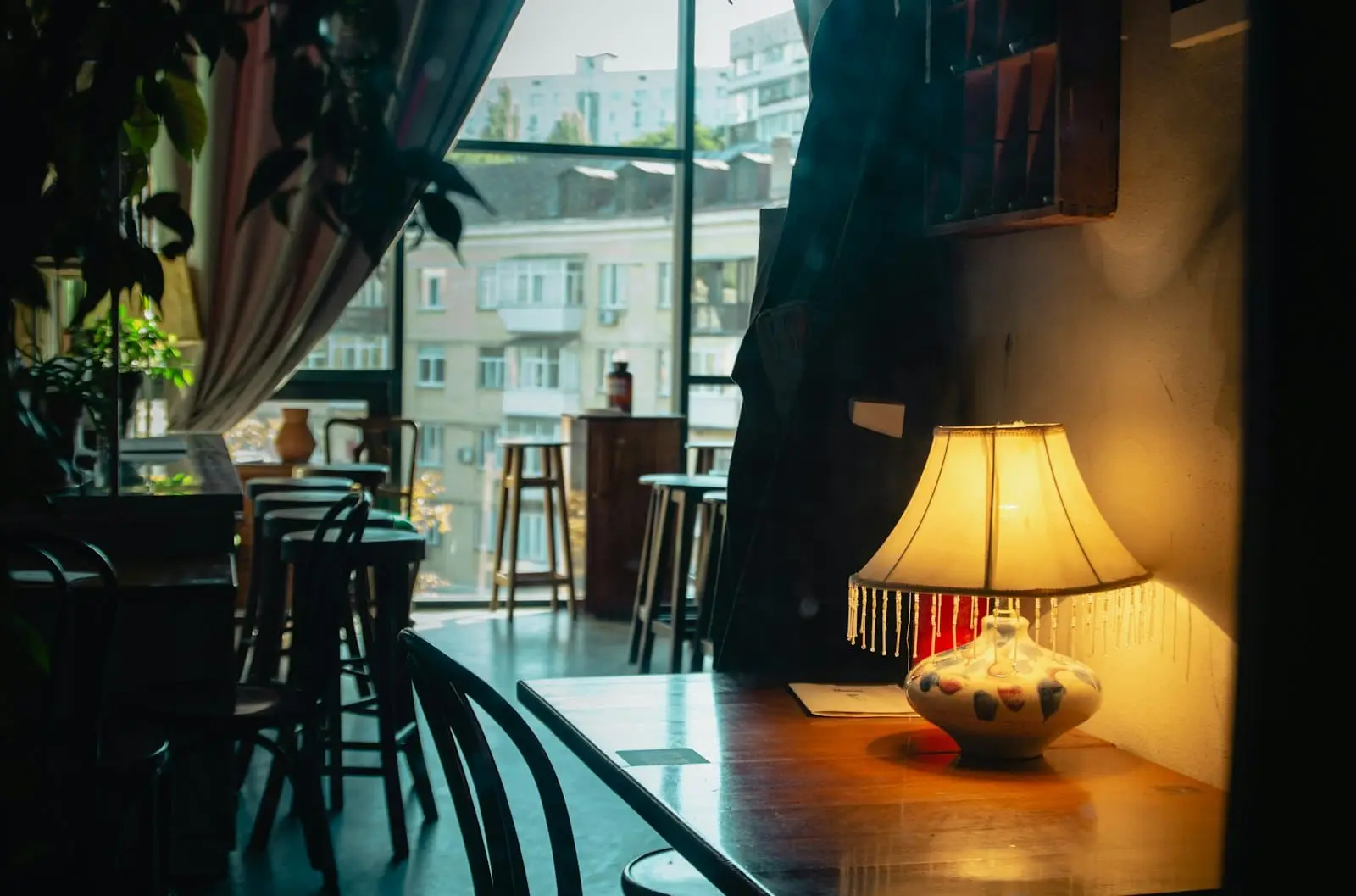 A table with a warm lamp beside a café window